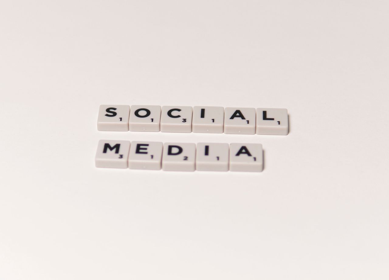 heros-img Scrabble tiles spelling social media on a white background, representing digital communication concepts.
